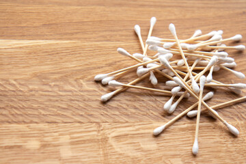 Set of bamboo cotton swabs on wooden background. Zero waste