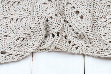 Fototapeta na wymiar Knitted sweater lying on a wooden background.