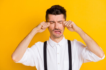 Photo portrait of childish guy grimacing crying tears unhappy sad frustrated touching face isolated on vibrant yellow color background