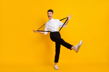 Fototapeta na wymiar Full length body size view of funny cheerful guy dancing pulling suspenders having fun isolated over bright yellow color background