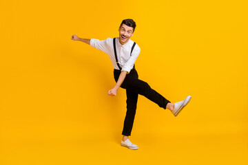 Fototapeta na wymiar Full length body size view of nice skinny cheerful guy dancing having fun isolated over bright yellow color background