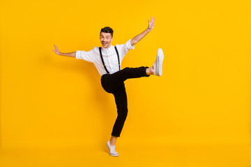 Fototapeta na wymiar Full length body size view of attractive skinny cheerful guy dancing having fun celebrating isolated over bright yellow color background