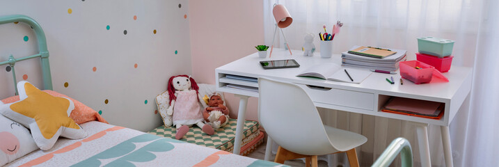 Girl's bedroom with bed and desk decorated in pastel colors