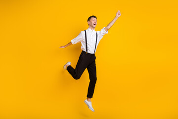 Fototapeta na wymiar Full length body size photo jumping dreamy man keeping hand up imagine keeping umbrella isolated on vivid yellow color background