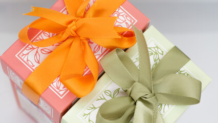 Pink gift box near the green box with bows for a celebration 