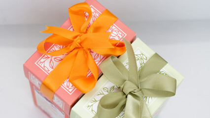 Pink gift box near the green box with bows for a celebration 