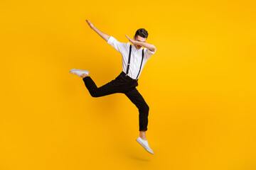 Full length body size photo of jumping man dancing hip-hop showing hype dab sign isolated on bright yellow color background