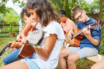 Gruppe Kinder im Gitarrenkurs übt Gitarre spielen