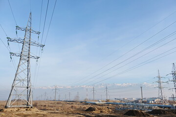 Almaty, Kazakhstan - 02.04.2021 : Power lines on the background of a large layer of smog covering the city and mountains.