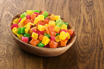 Candied fruits on wooden background.