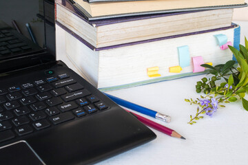 computer notebook with dictionary book of student for study decoration on background white wooden