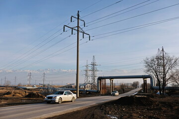 Almaty, Kazakhstan - 02.04.2021 : The road along the power lines and pipes of the heating plant