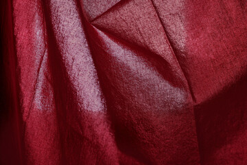 Fiery red fabric with shadow streaks.