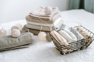 Laundry, towels folded and rolled in baskets in bedroom. Concept of tidiness, minimalism lifestyle and japanese folding system. Organizing wardrobe, stuff in boxes