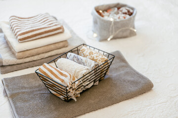 Laundry, towels folded and rolled in baskets in bedroom. Concept of tidiness, minimalist lifestyle and konmari folding system. Organizing wardrobe, stuff in boxes