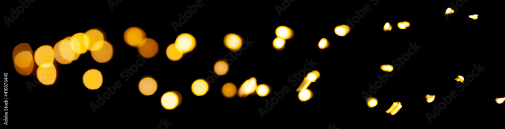 Poster yellow bokeh lights on a black background. abstract shiny pattern in defocus.