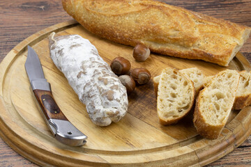 saucisson sec aux noisettes et pain sur une planche à découper
