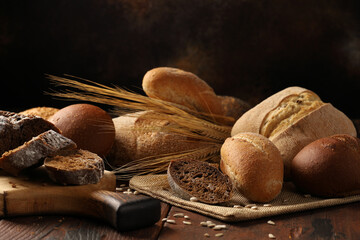 Assorted rye and wheat bread, wheat and corn rolls, fresh ciabatta, garnished with ears of wheat.