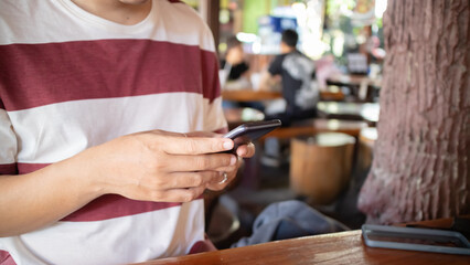 Hand using smartphone in restaurant.