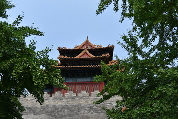 View of a Beautiful Pagoda Building Framed by Leafy Trees and a Blue Sky Above