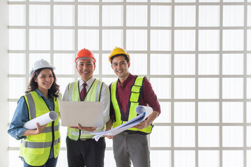 Three Asian engineers team, two men and one woman working together in an outdoor construction site