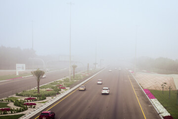 Road in the fog, sign mention keep distance for motorists at dubai road, foggy weather in UAE, Dense Fog keep Safe Distance banner in arabic and english