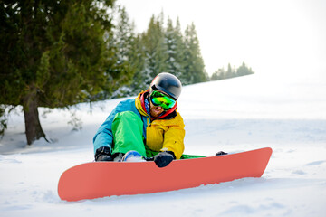 Snowboarder Getting Ready for Riding Snowboard in the Mountains. Snowboarding and Winter Sports