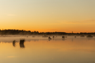 Silhouette of kayak canoe boats at sunrise in the lake. Early summer morning
