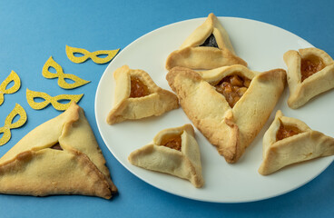Hamantaschen cookies or hamans ears and  masks  for Purim celebration (Jewish carnival holiday).  Selective focus.