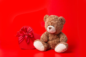 teddy bear heart shaped box on red background valentine's day