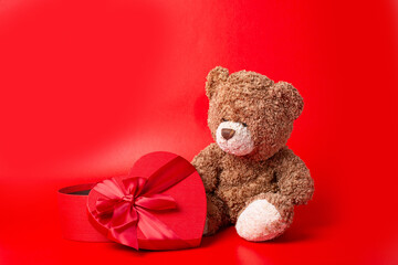 teddy bear heart shaped box on red background valentine's day