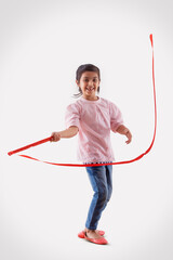 young girl playing with a ribbon wand	