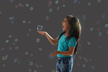 portrait of a young girl holding a bubble in her hand	