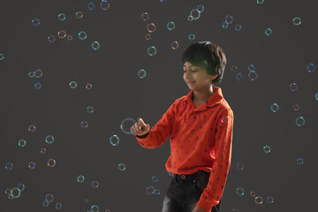 portrait of a young boy playing with bubbles	