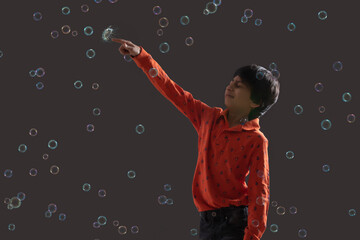 portrait of a young boy popping a bubble	