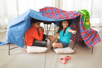 brother and sister camping at home	