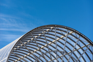 Closeup of a modern glass and steel architecture on blue sky with clouds. La Spezia, Italy, Europe.