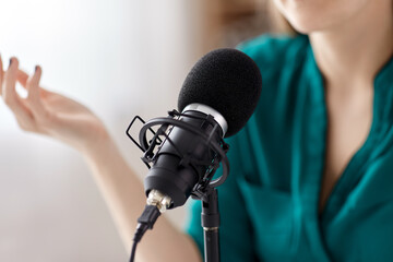 technology, mass media and people concept - close up of woman with microphone and headphones...