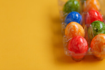 Easter card. Flat lay composition with easter eggs in plastic packaging on yellow background.