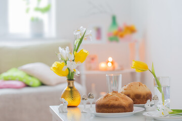 Fototapeta na wymiar Easter cakes with spring flowers in white interior