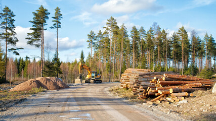 Yellow excavator building a road deep in the forest. Rusko, Finland.