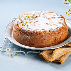Healthy Wholemeal apple cinnamon tea cake on light blue background with copy space. Homemade baked concept. Mother's Day, Birthday Cake card Background. Summer, Spring time recipe.