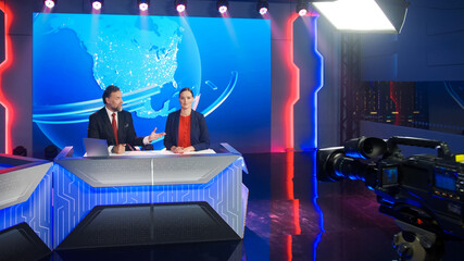 Live News Studio with Beautiful Female and Handsome Man Anchors Start Reporting. TV Broadcasting...