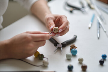 Craft jewelery making with professional tools. Jewelry designer working in studio with tools making...
