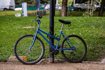 Fototapeta premium Closeup shot of a blue bicycle locked on a street light 