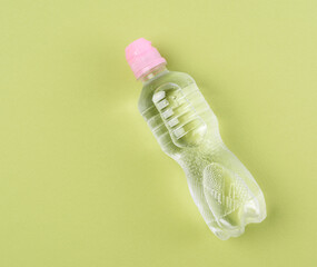transparent plastic bottle with fresh water on a green background