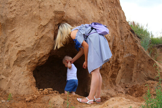 Girl And Little Boy On A Rock