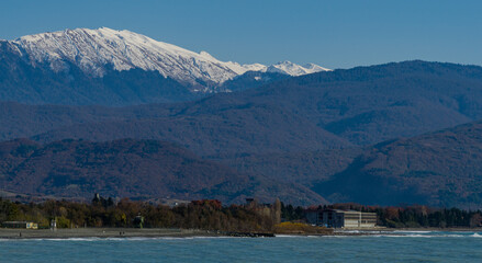Fototapeta na wymiar View of snowy peaks of Caucasian mountains in Abkhazia across Black Sea from Russian side.