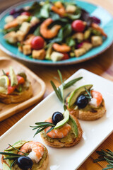 Appetizer canape with shrimp and cucumber on plate on table close up