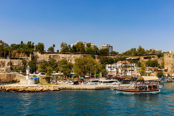 Fototapeta na wymiar Antalya, Turkey - August 27, 2013: Anchored in the marina, historic yachts and tourist boats view of the blue sea in Kaleici, Antalya, Turkey. Selective focus. Holiday consept.